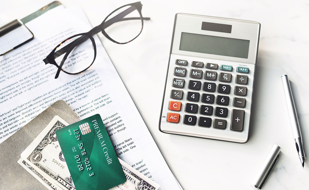 Calculator, money and credit card on money.