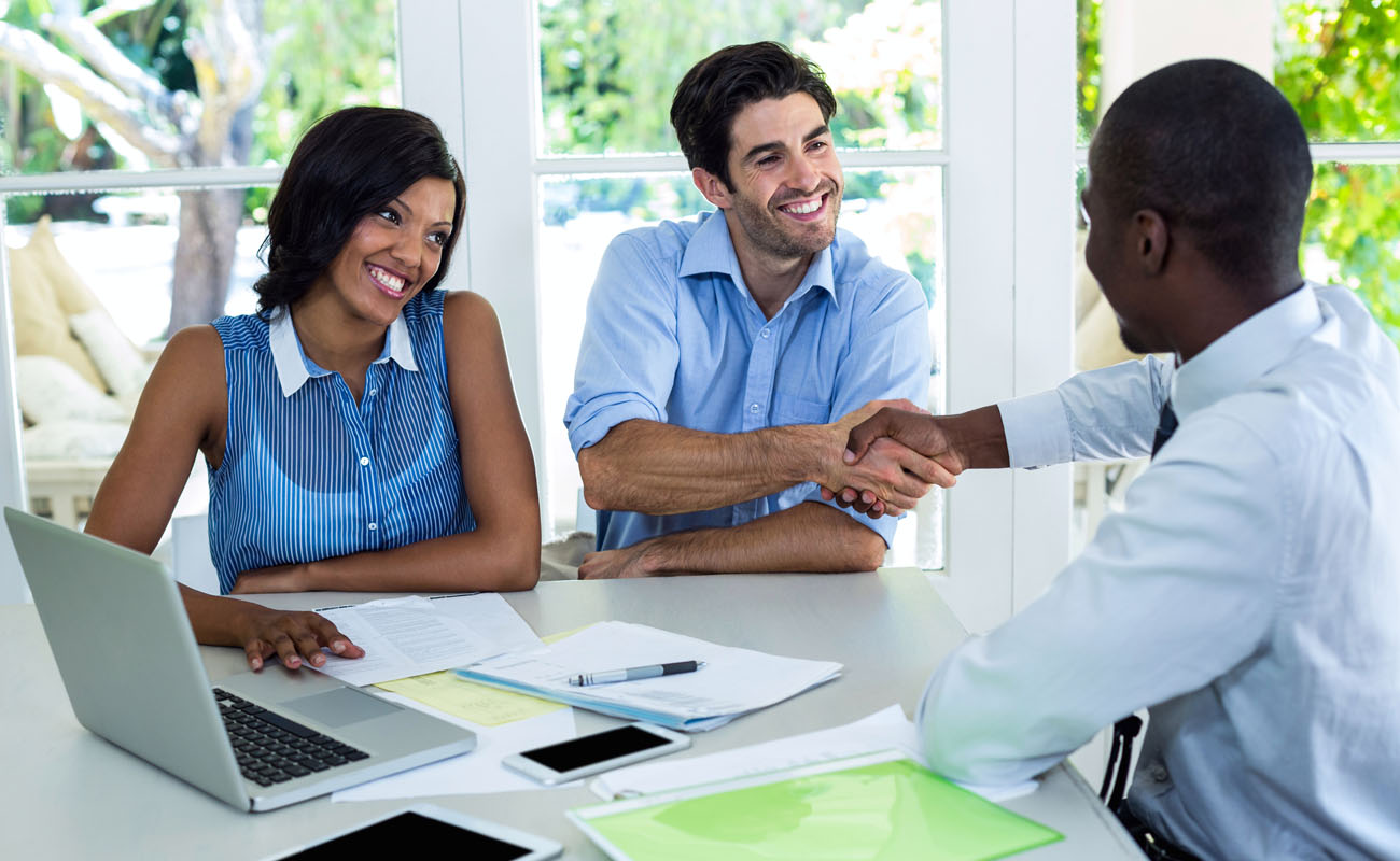 Couple having successful negotiations with agent.