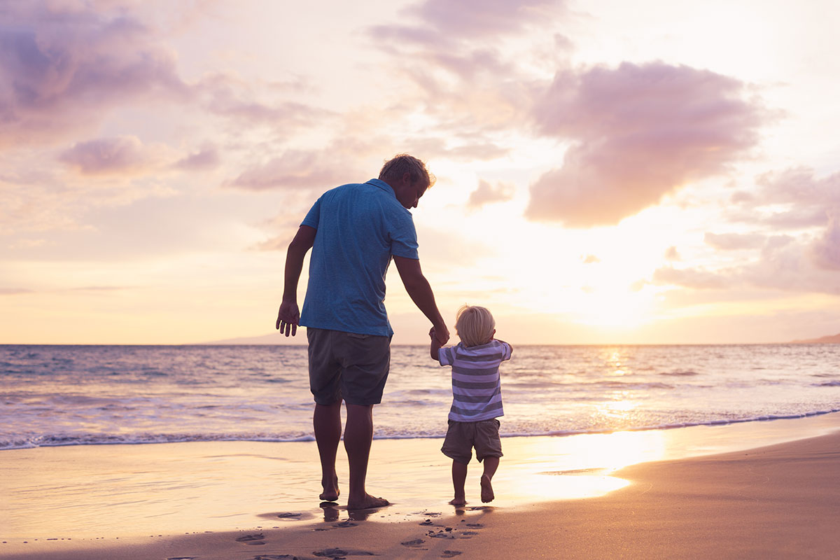 Father and Son Walk on a Beach.