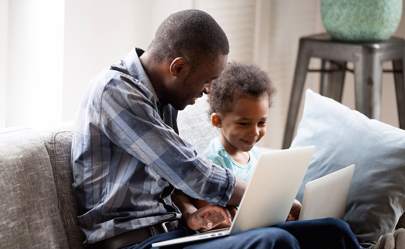 Father teaches son at home.