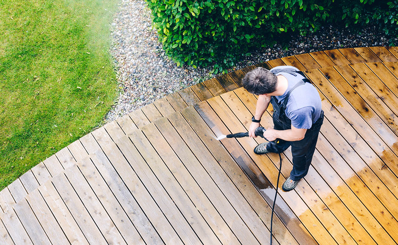 Man power washing deck.