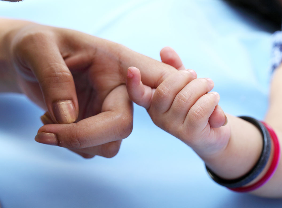 Mother and Baby Holding Hands.