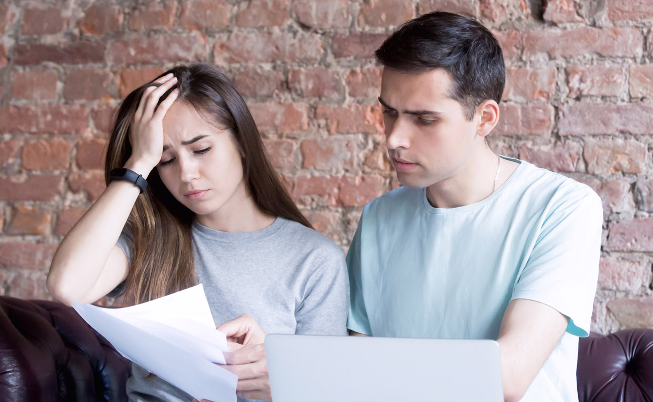 Young couple shocked with monthly bills.
