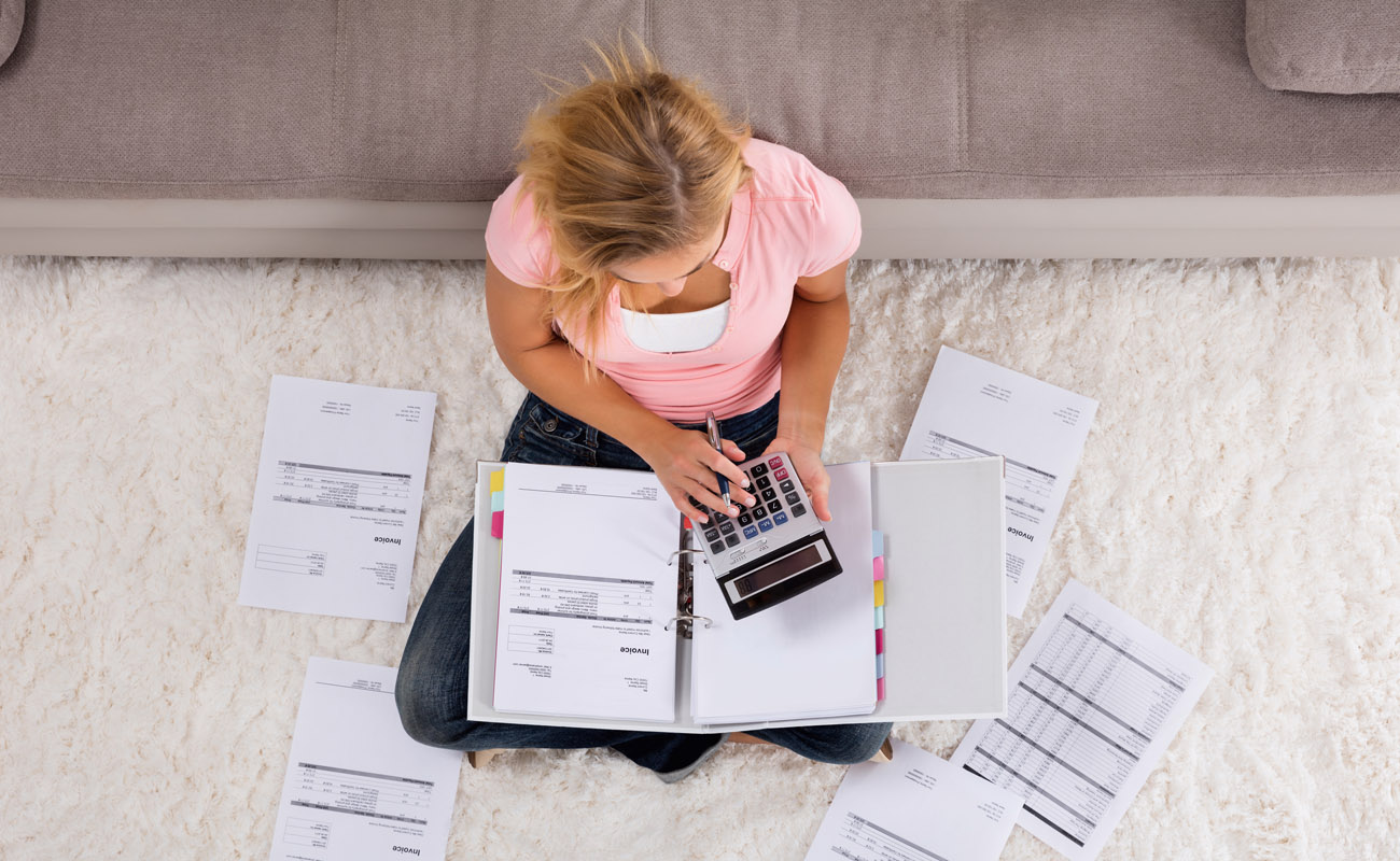 Young woman calculating her budget.